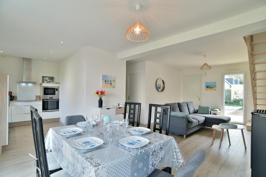 une salle à manger et un salon avec une table et des chaises dans l'établissement Les Belles Noës, à Saint-Briac-sur-Mer