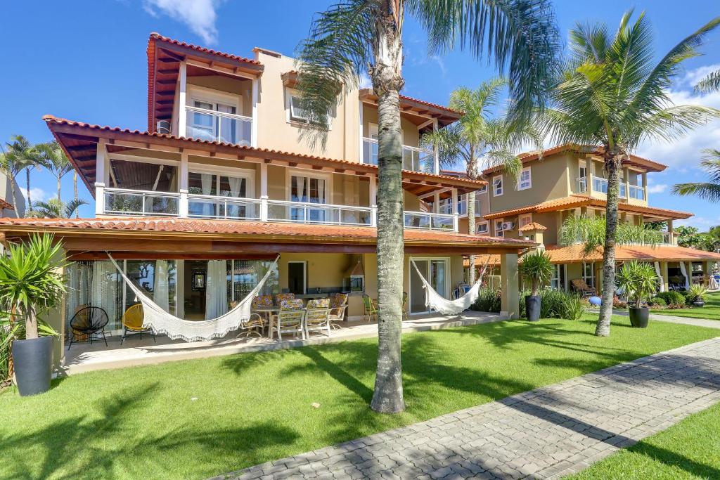 una vista exterior de una casa con palmeras en Villas Jurerê Residences, en Florianópolis