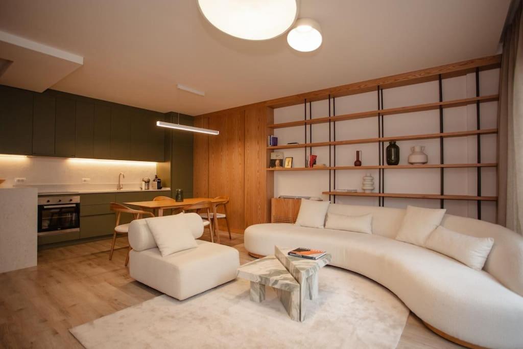 a living room with a white couch and a table at The Luxury Garden Apartment in Shkodër
