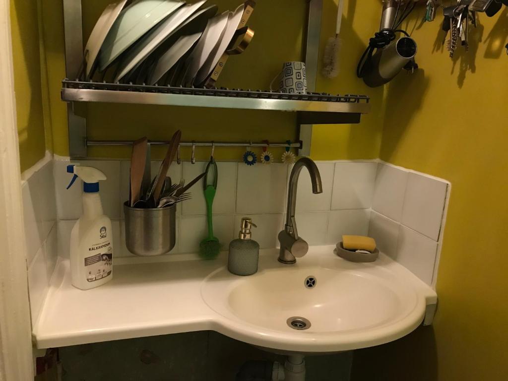 a sink in a small bathroom with a sink at Cozy condo for up to 3 travellers, with kitchen and bath in Rīga
