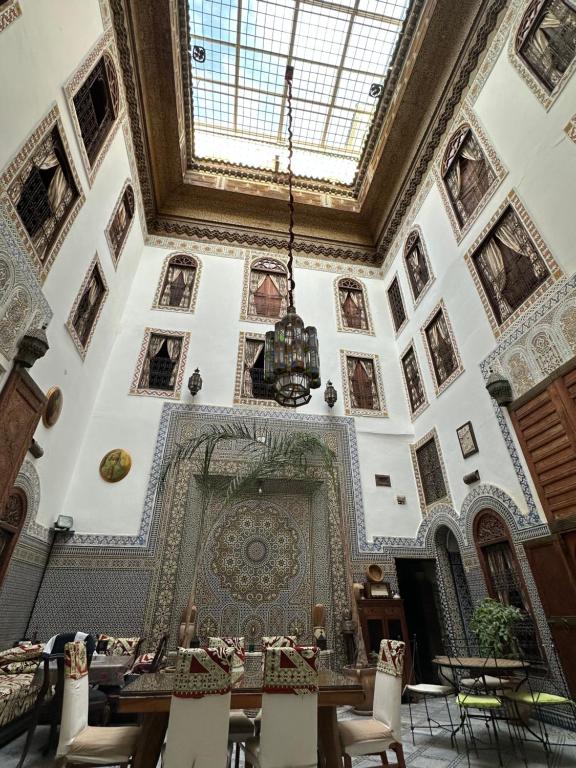 Habitación grande con techo, mesa y sillas. en Riad Le Patio De Fes, en Fez