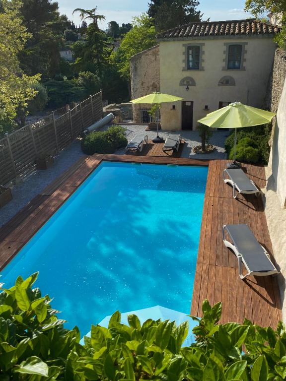 a swimming pool in front of a house at Logis Hôtel Château De Palaja in Carcassonne