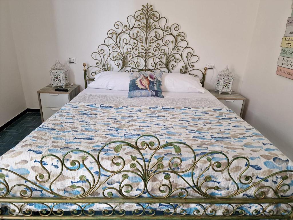 a bed with a quilt on it in a bedroom at Una finestra sul mare accanto alle 5 Terre in Levanto