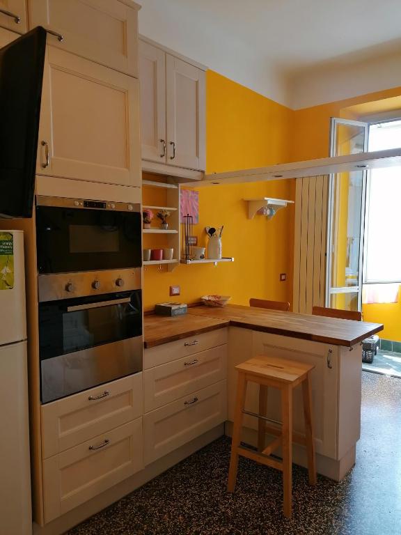 eine Küche mit gelben Wänden und einem Herd mit Backofen in der Unterkunft La volpe gialla in Savona