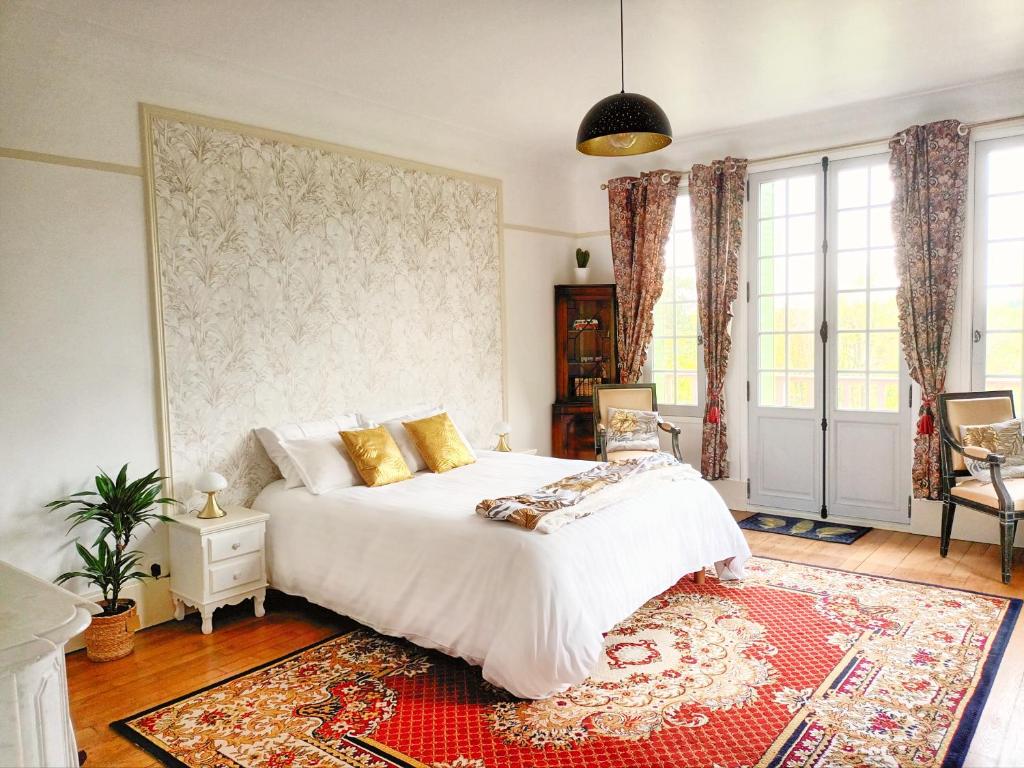 a bedroom with a white bed and a red rug at Le Manoir du Cerf in Gaillon-sur-Montcient