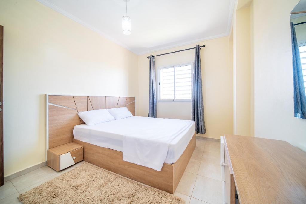 sypialnia z białym łóżkiem i oknem w obiekcie Appartement 2 chambre 5min Aéroport w Marakeszu