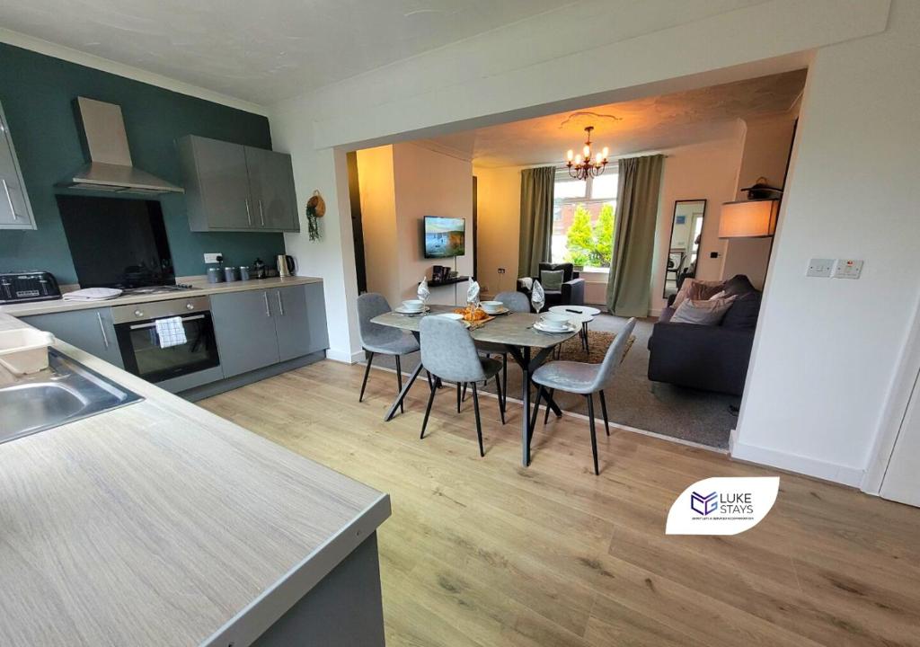 a kitchen and living room with a table and chairs at Luke Stays - Chilside Road in Felling