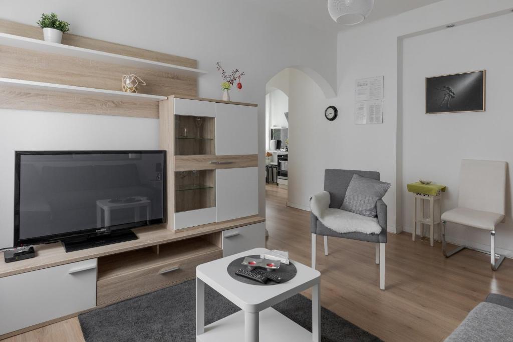 uma sala de estar com uma televisão de ecrã plano e uma mesa em Lisinski apartment with private parking em Zagreb