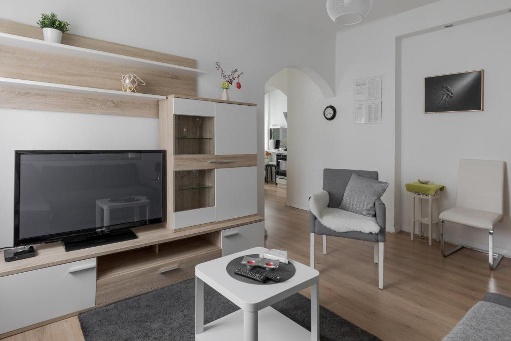 een woonkamer met een flatscreen-tv en een tafel bij Lisinski apartment with private parking in Zagreb
