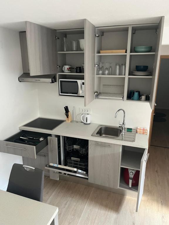 una cucina con armadi grigi e lavandino di Apartma Melinc a Bovec