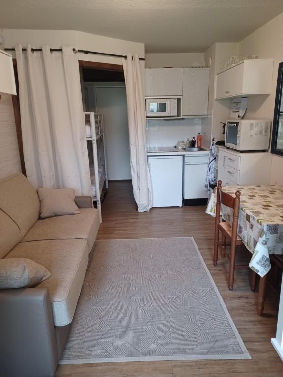 ein Wohnzimmer mit einem Sofa und einem Tisch sowie eine Küche in der Unterkunft le chamois d or in Allos