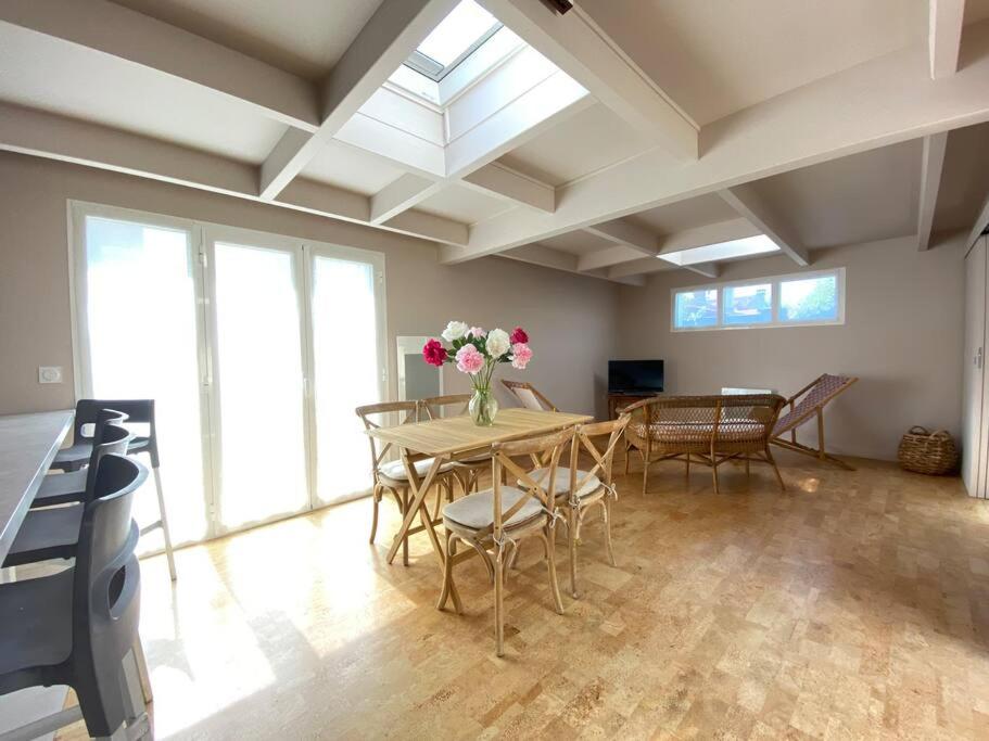 una sala da pranzo con un tavolo con sopra dei fiori di Dépendance complète centre-ville de La Teste a La Teste-de-Buch