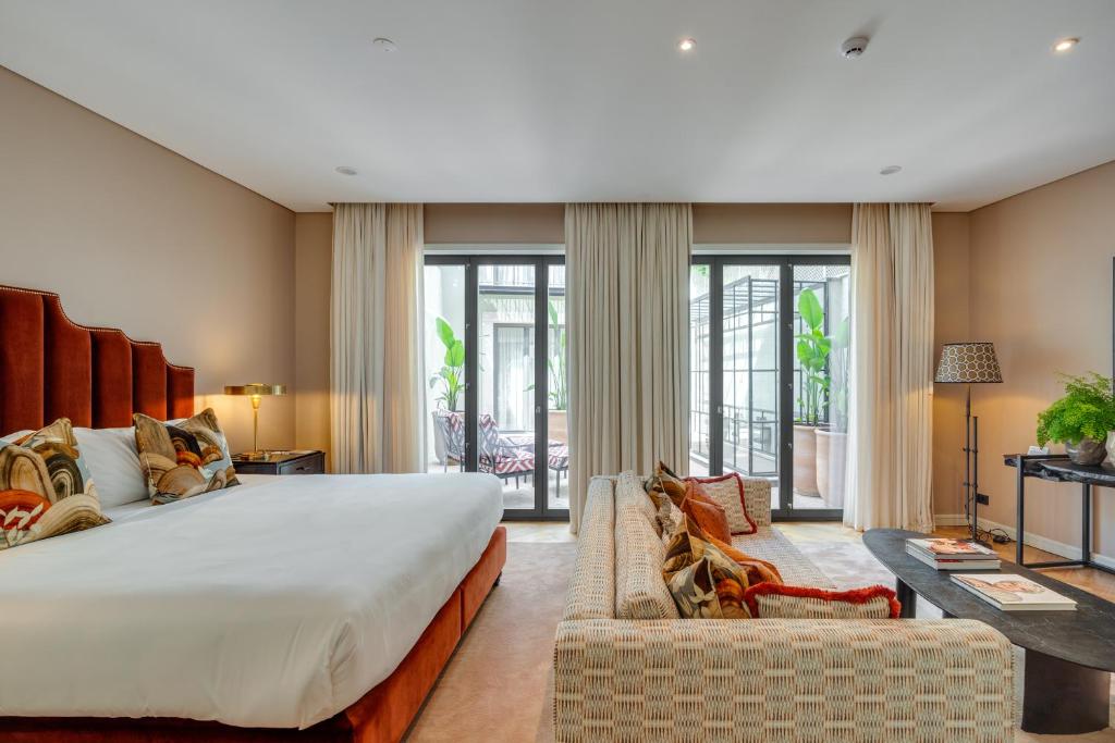 a large bedroom with a large bed and a couch at Portie Deluxe Suites by DA'HOME in Porto