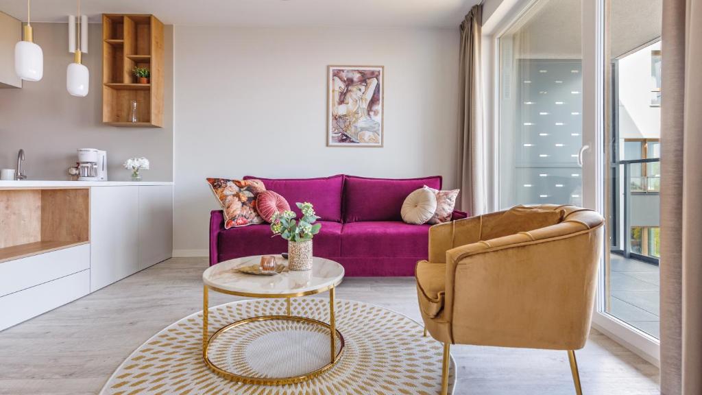 sala de estar con sofá púrpura y mesa en Apartamenty Sun & Snow Modern Tower en Gdynia