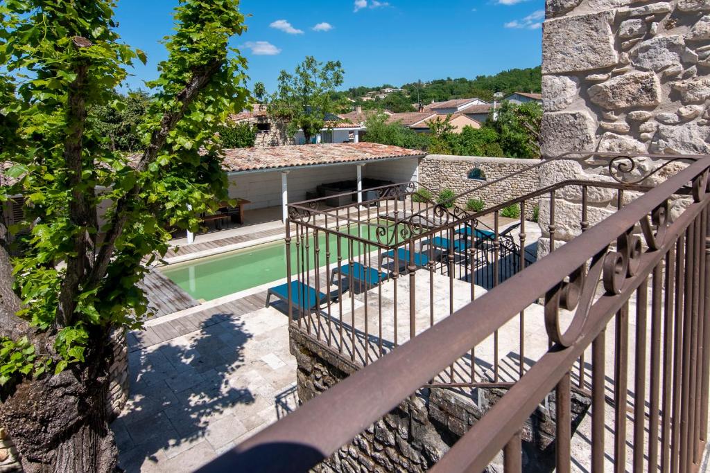 a balcony with a swimming pool and a house at Mas Picholine - Maison pour 10 avec piscine in Saint-Jean-de-Maruéjols-et-Avéjan