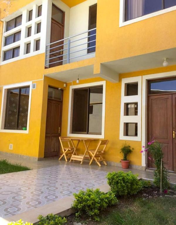 a yellow building with a picnic table in front of it at Bonita casa acogedora in Cochabamba