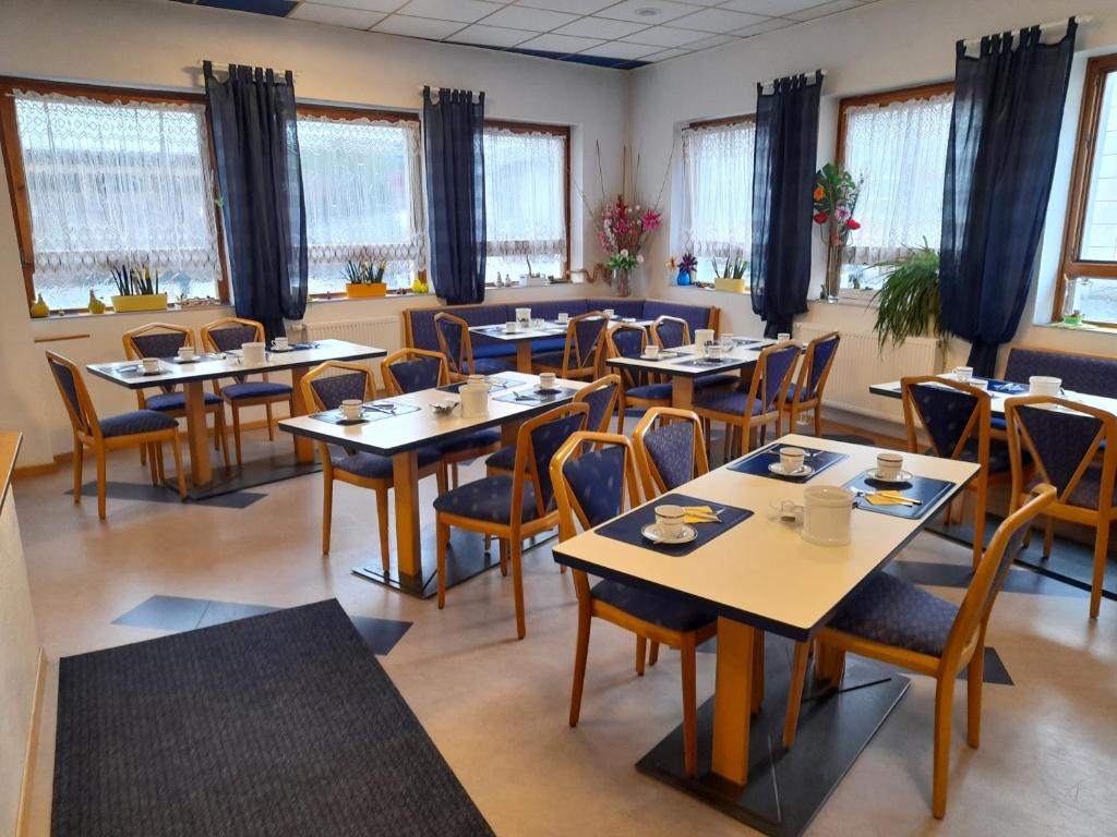 a dining room with tables and chairs and windows at Smile Hotel in Nuremberg