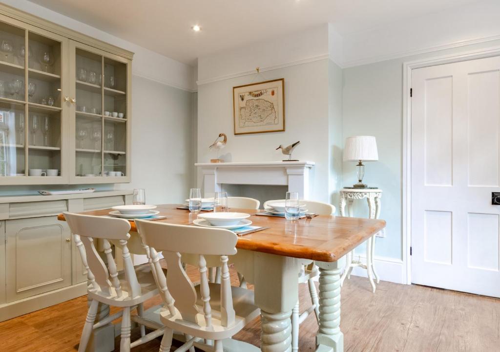 Albert Cottage في هولت: غرفة طعام مع طاولة وكراسي خشبية
