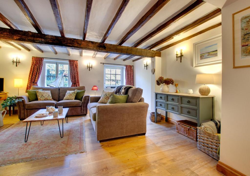 a living room with a couch and a table at Angel Cottage in Burnham Market