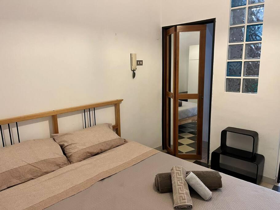 1 dormitorio con cama y espejo en Appartamento Domarì, en Turi