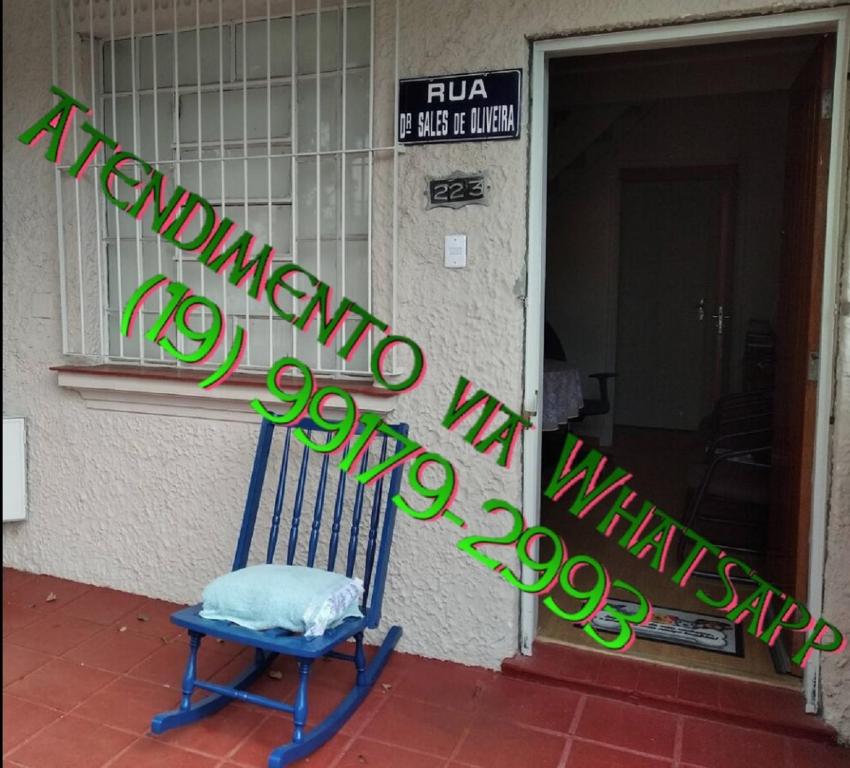 a blue chair in front of a building with a sign at Pousada Seu Jorge in Campinas