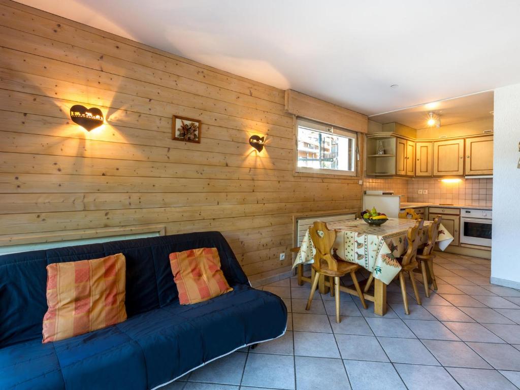 un salon avec un canapé bleu et une table dans l'établissement Duplex 2 chambres au centre du village, proche pistes de ski, parking inclus, La Clusaz - FR-1-437-40, à La Clusaz