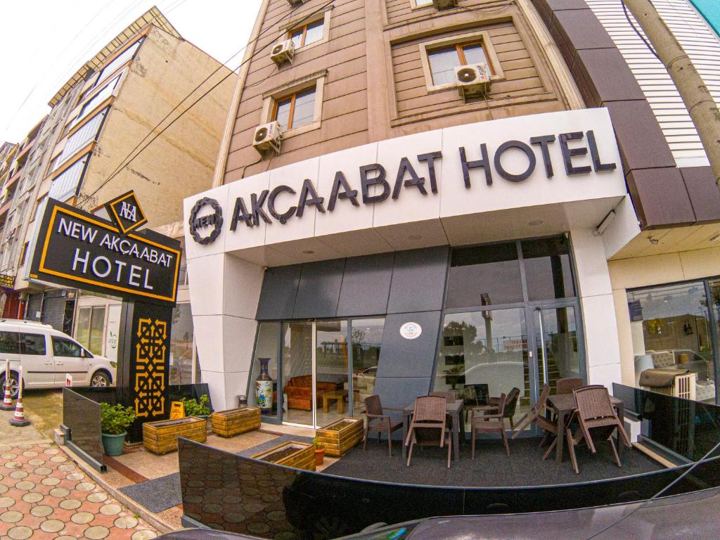 New Akçaabat Hotel في اكشبات: مطعم فيه طاولات وكراسي امام مبنى