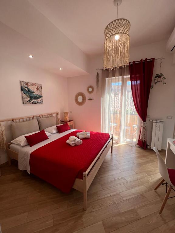 - une chambre avec un grand lit et une couverture rouge dans l'établissement Casa Dharma, à Civitavecchia