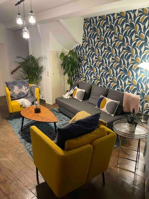 a living room with couches and chairs and a wall at B&B ArdennesT in Bouillon