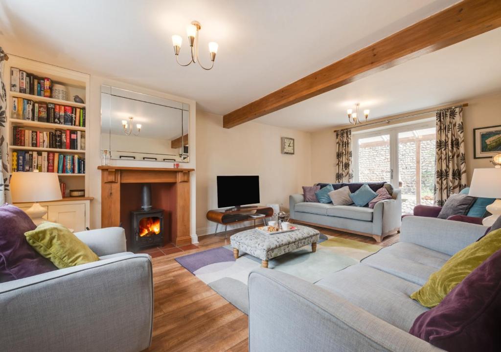 a living room with two couches and a fireplace at Box House in Bodham