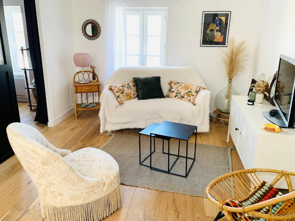 un salon avec un canapé et deux chaises dans l'établissement Charmant T2 très cosy au calme en hyper centre., à Rochefort