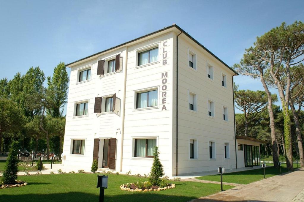 un edificio blanco con un cartel. en MiMa Hostel Moorea, en Milano Marittima