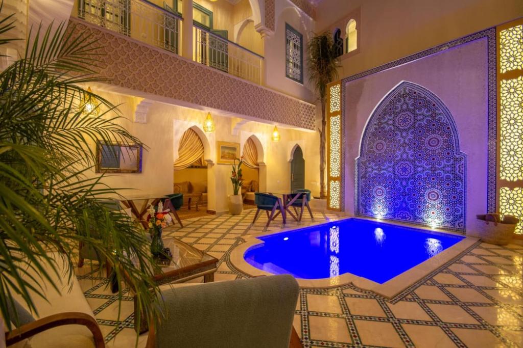 a house with a blue pool in a room at Riad Jalina in Marrakesh
