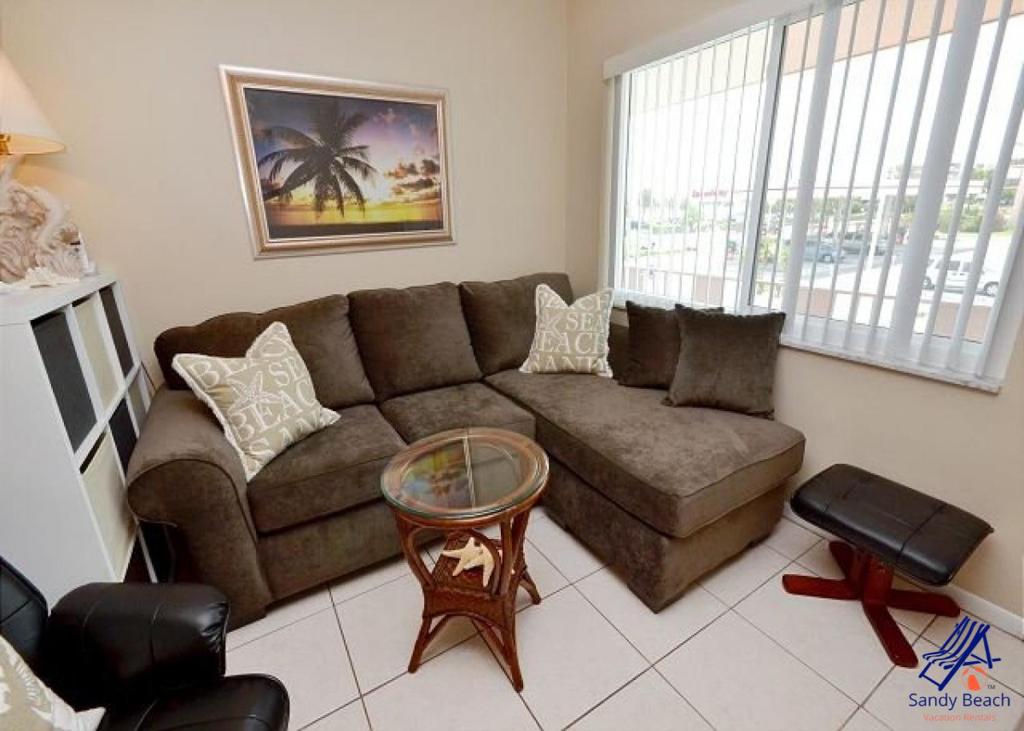 ein Wohnzimmer mit einem Sofa und einem Tisch in der Unterkunft Tropic Breeze 17 in St Pete Beach