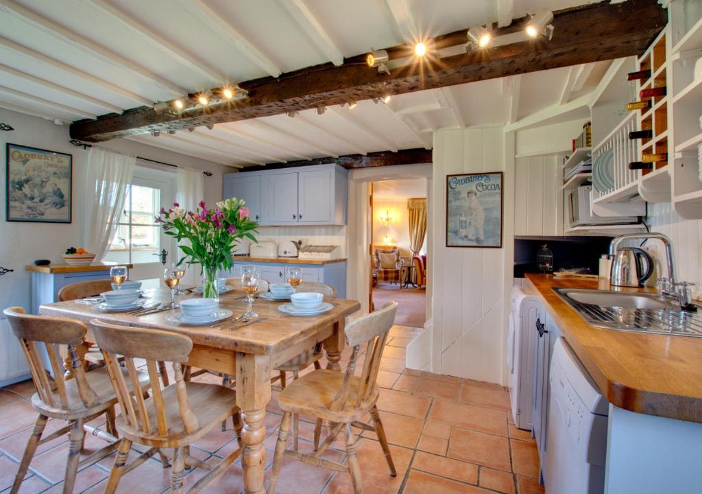 a kitchen and dining room with a wooden table and chairs at Cockleshells in Castle Acre