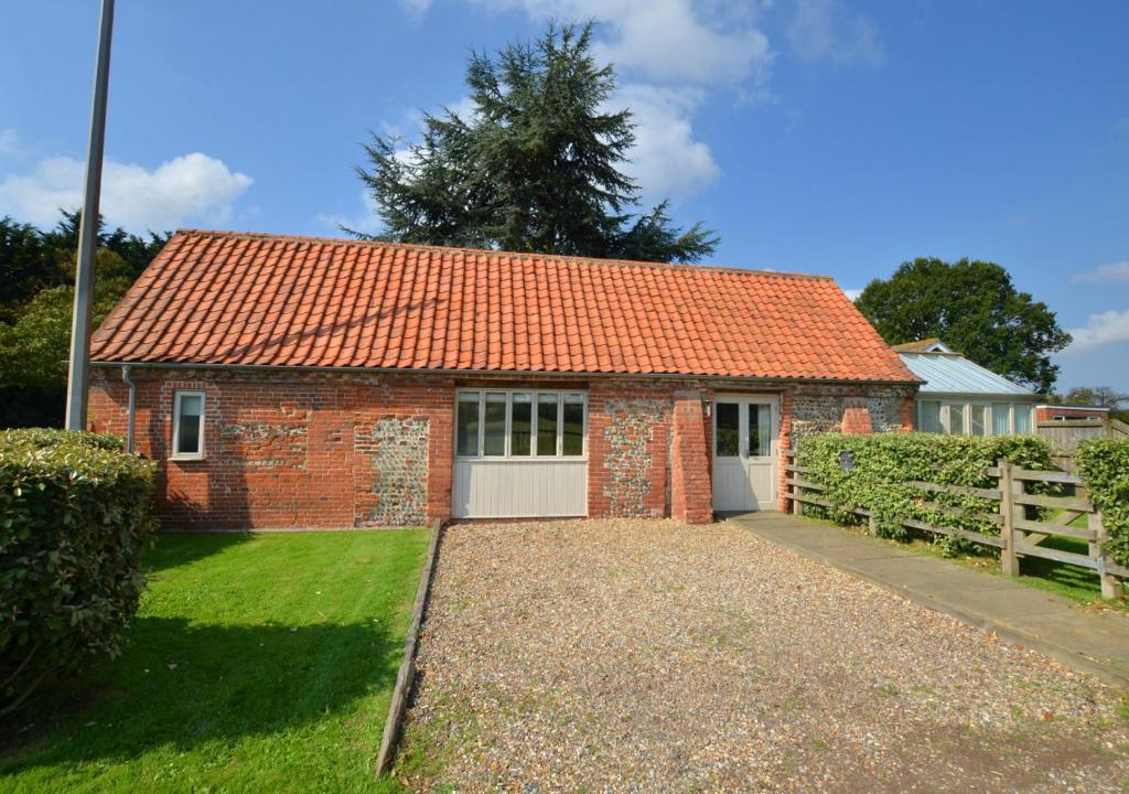 a small brick house with an orange roof at Crossways Barn in Briston