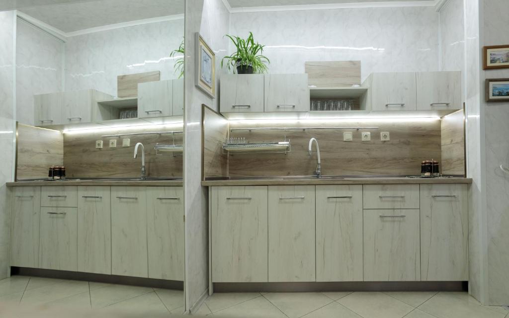 a kitchen with two sinks and two faucets at Apart & Rooms Fotinov in Burgas City