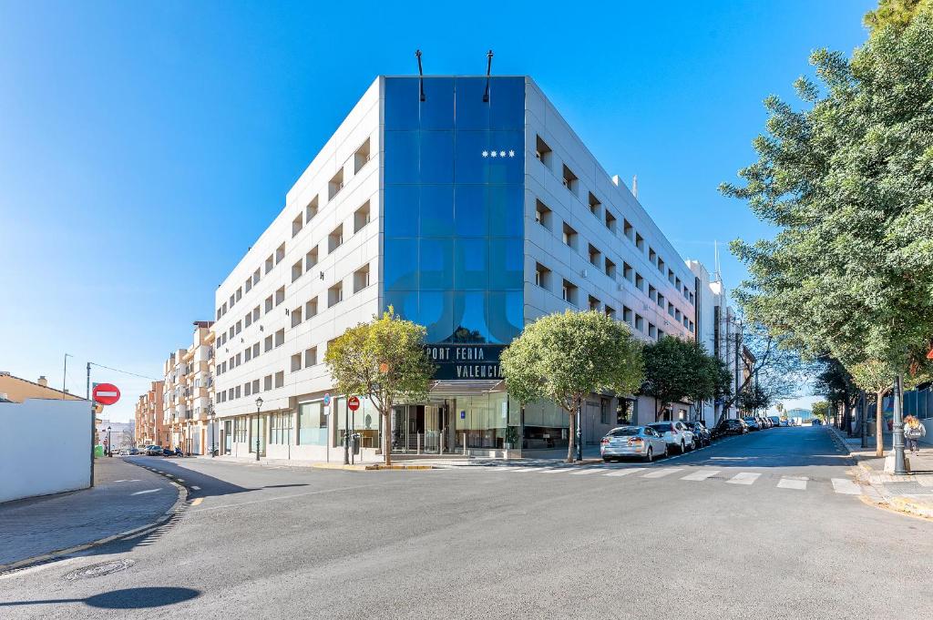 un grand bâtiment dans une rue de la ville avec un parking dans l'établissement Port Feria Valencia, à Valence