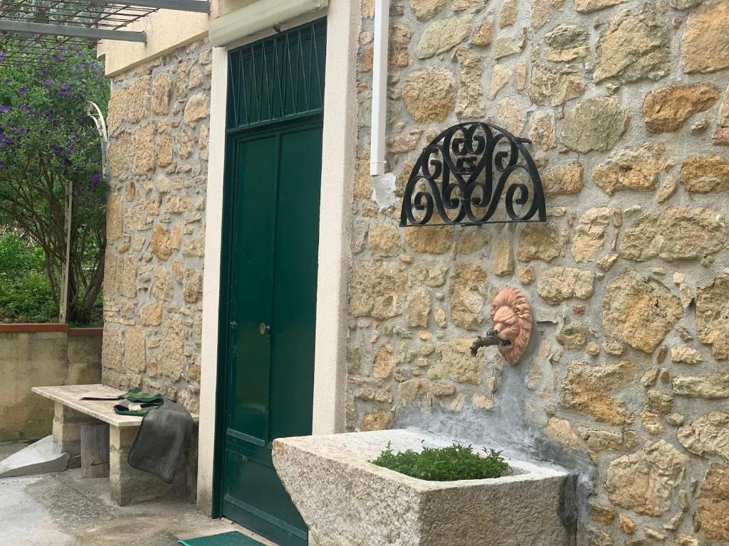 un edificio de piedra con una maceta delante de una puerta en Azienda agricola La Torre, en Corleone