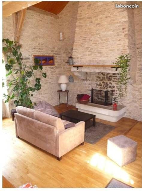 - un salon avec un canapé et une cheminée en pierre dans l'établissement Gîte du Plaçal, à Aujols