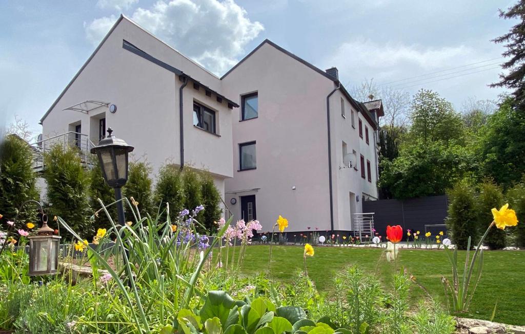 ein weißes Haus mit einem Garten davor in der Unterkunft Sonnenlay Lounge - Studio & Ferienhaus in Brauneberg