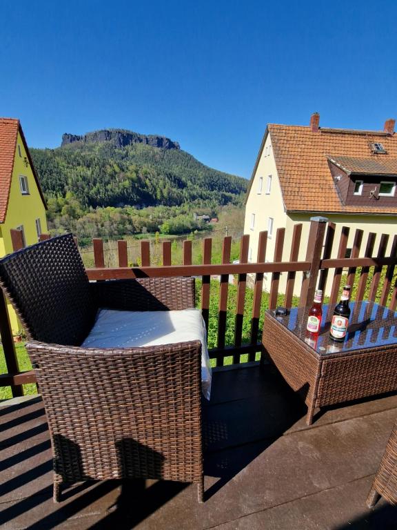 een balkon met 2 stoelen en een tafel met 2 flessen bij Tinyroom mit Ausblick in Königstein an der Elbe