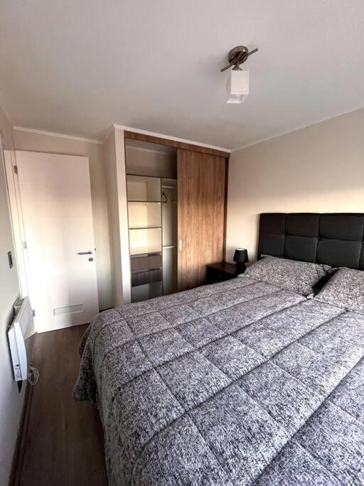 Un dormitorio con una cama grande y un ventilador de techo. en Centro Temuco, en Temuco