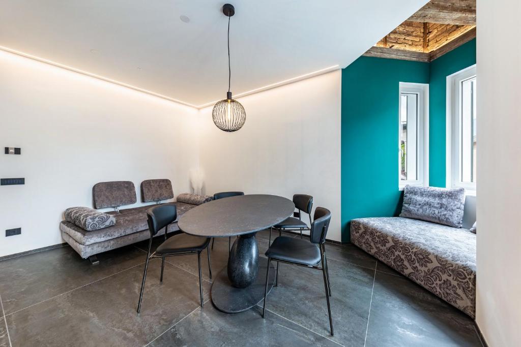 sala de estar con mesa, sillas y sofá en App 205 Palazzo Cavour, en Bolzano