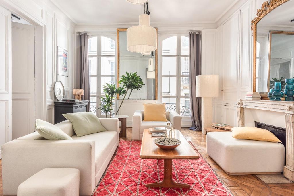 ein Wohnzimmer mit weißen Möbeln und einem roten Teppich in der Unterkunft Outstanding Parisian flat in heart of Paris center in Paris