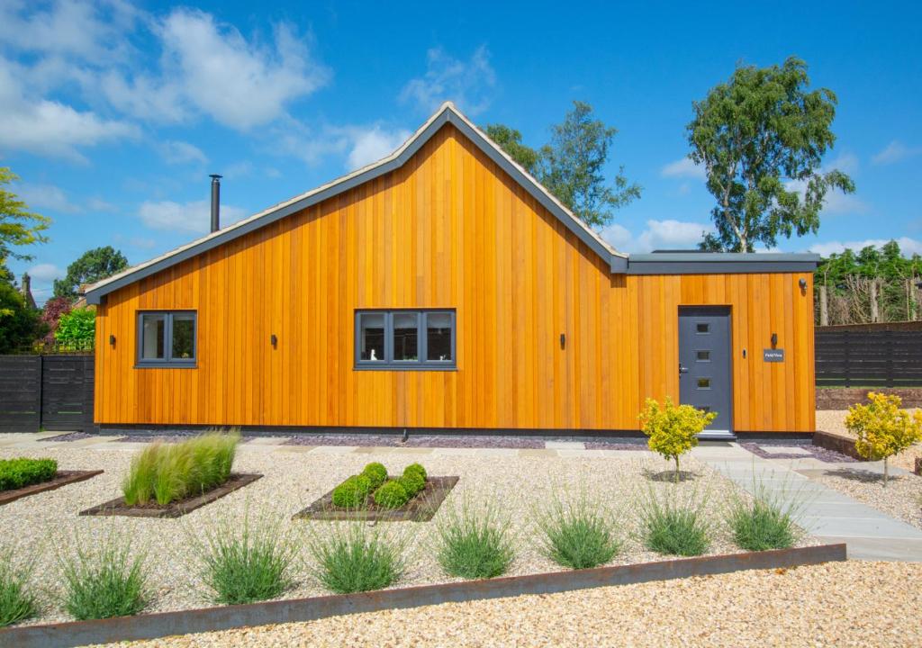 a large orange barn with a courtyard at Field View in Hindolveston