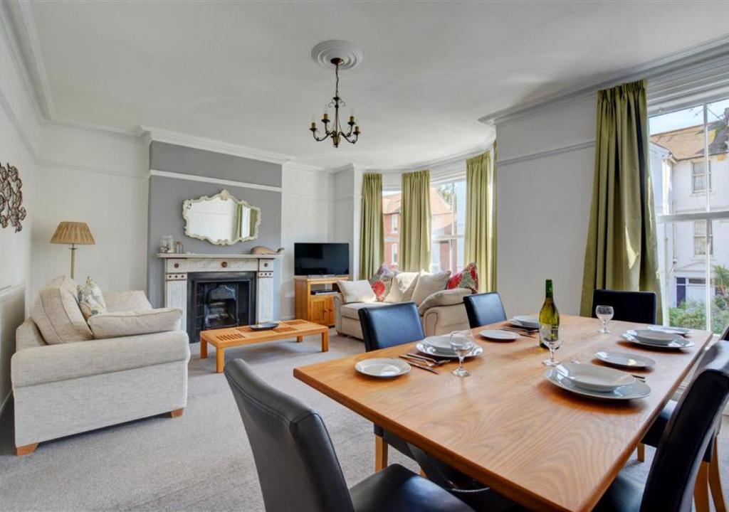 a living room with a large wooden table and chairs at Flat 2 in Cromer
