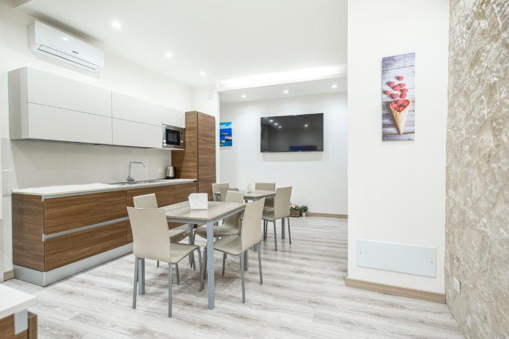 una cucina e una sala da pranzo con tavolo e sedie di B&B Ambitious a Catania