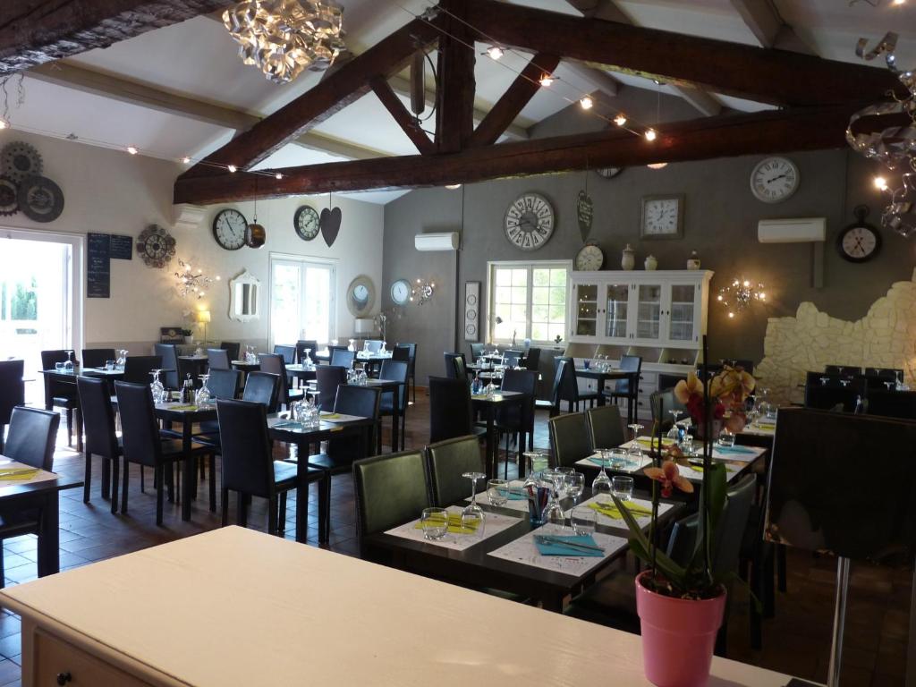 a restaurant with tables and chairs in a room at L'Horloge Gourmande in Donzère