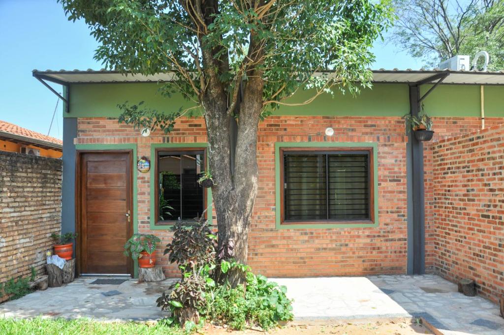 una casa di mattoni con un albero di fronte di Hospedaje CNR a San Lorenzo